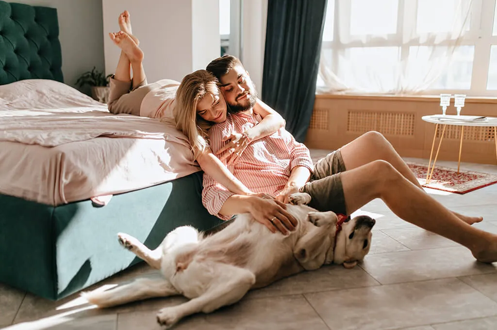 pareja con perro en habitación de hotel