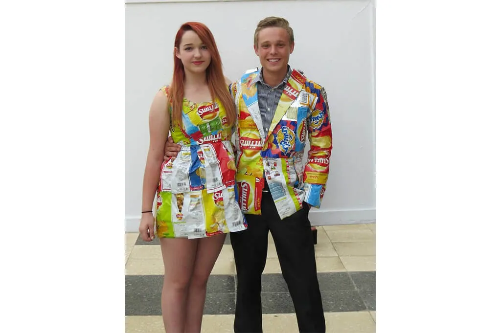 pareja con vestido y chaqueta elaborados con envolturas vacías de snacks